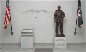 Photo of the OSS Memorial, a single star and inscription on the south wall in the Headquarters main lobby, opposite the Memorial Stars and a statue of OSS Director, William J. Donovan